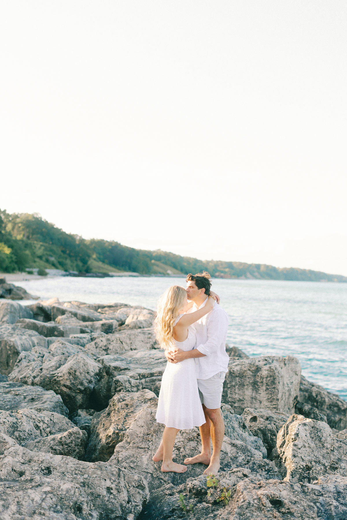 Him kissing her forehead on rocks