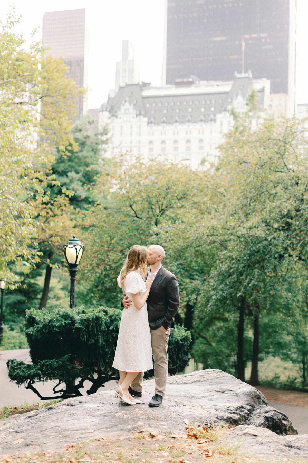 Couple standing on rock with skyline behind them