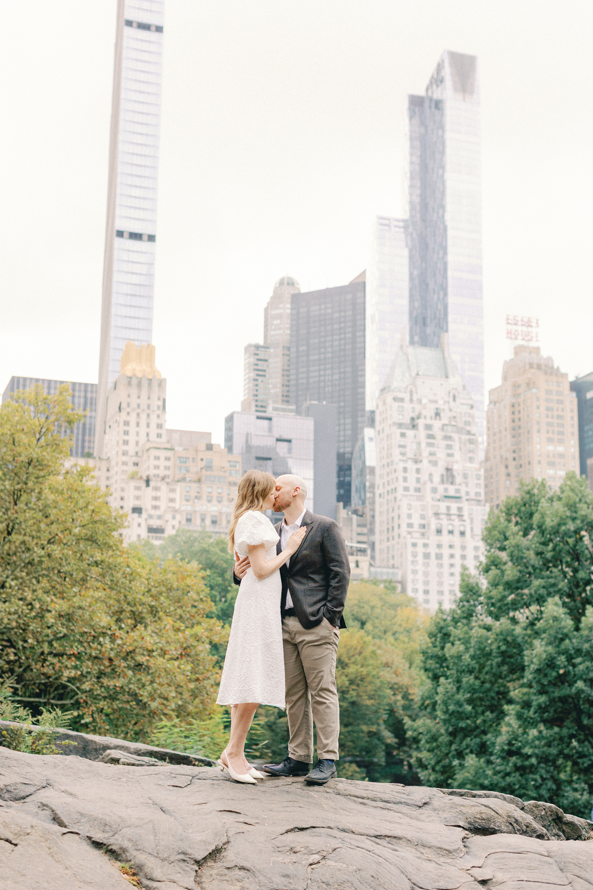 Couple standing on rock with New York City behind them