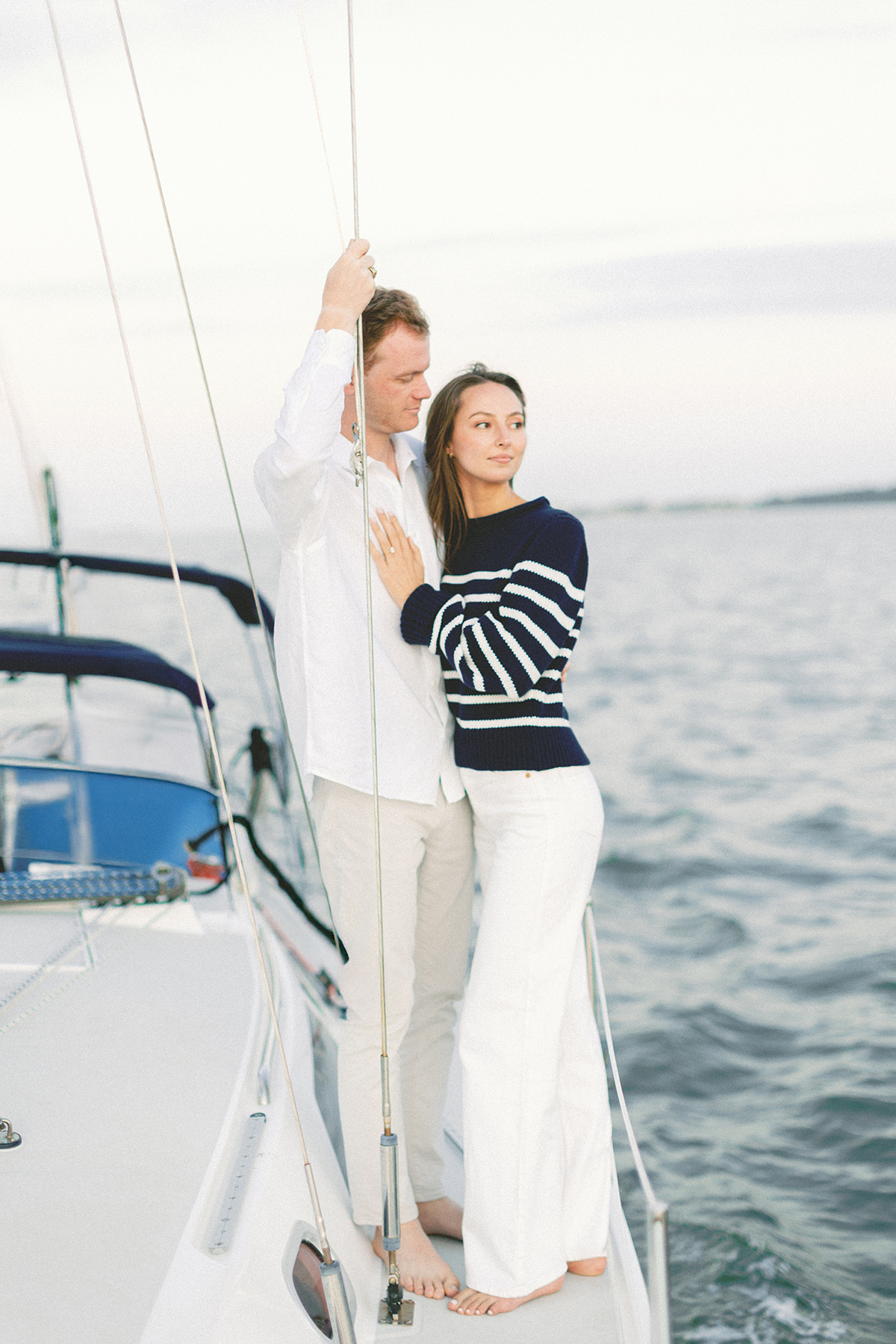 Couple standing on the edge of sailboat
