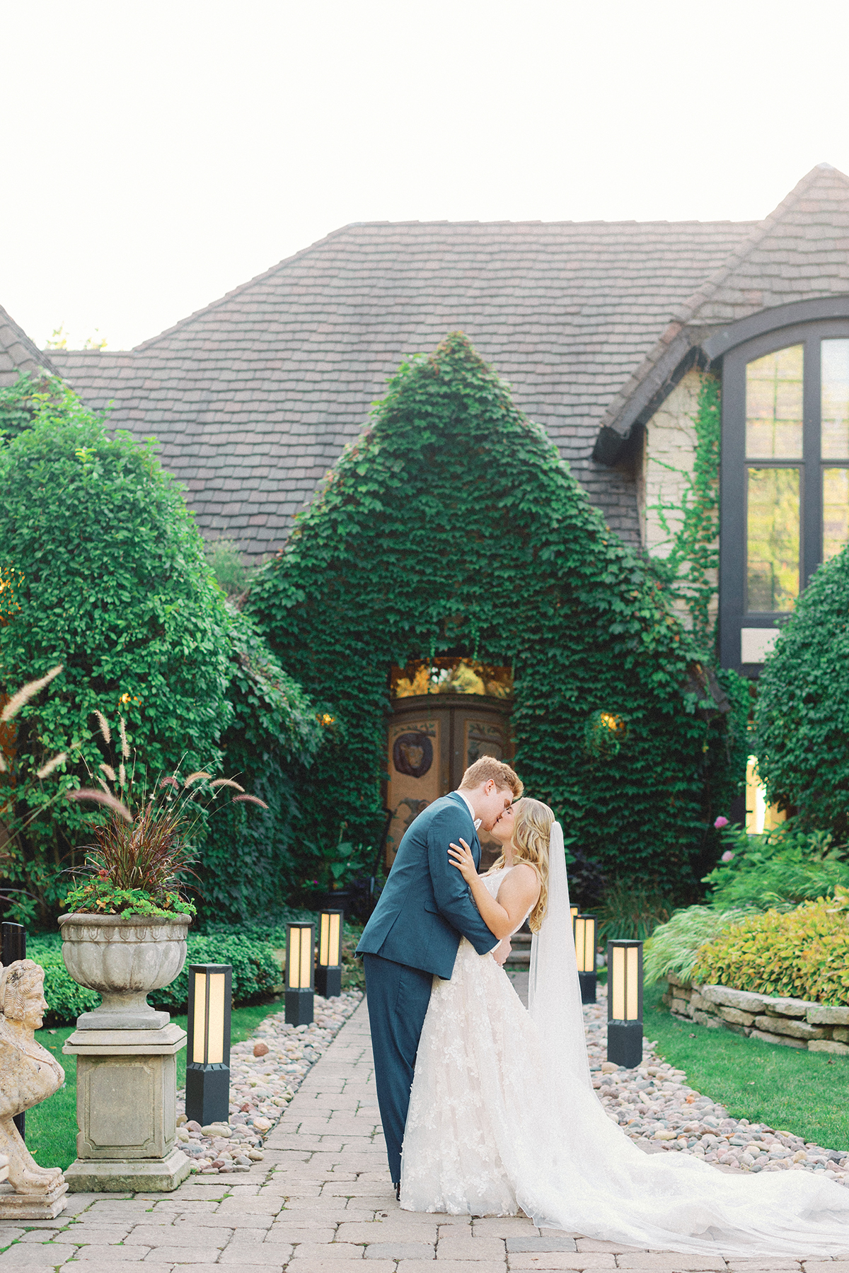 couple kissing in front of estate mansion