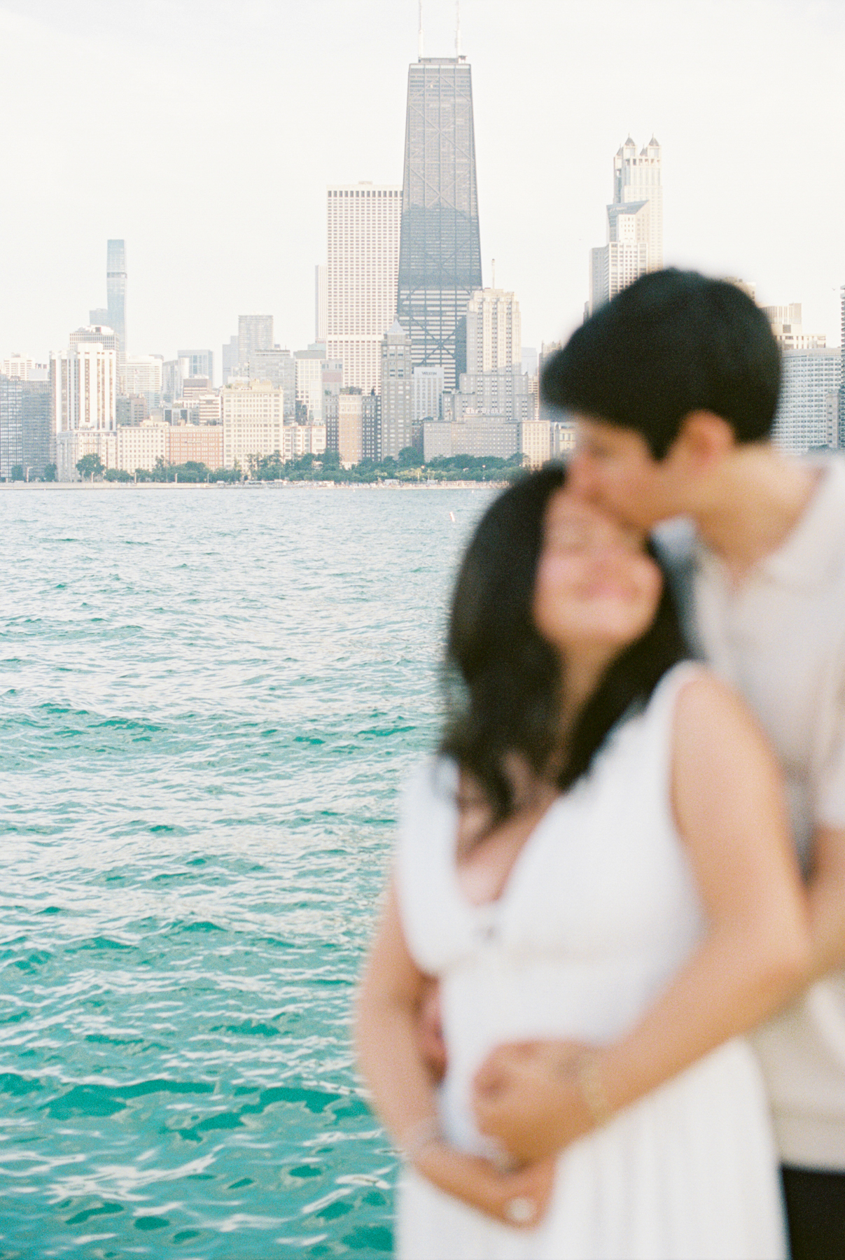 Couple out of focus with Chicago in the background