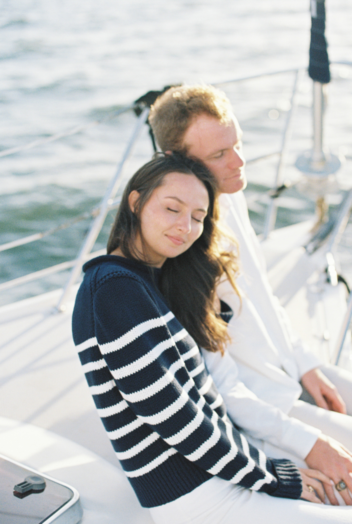 Couple snuggling on sailboat
