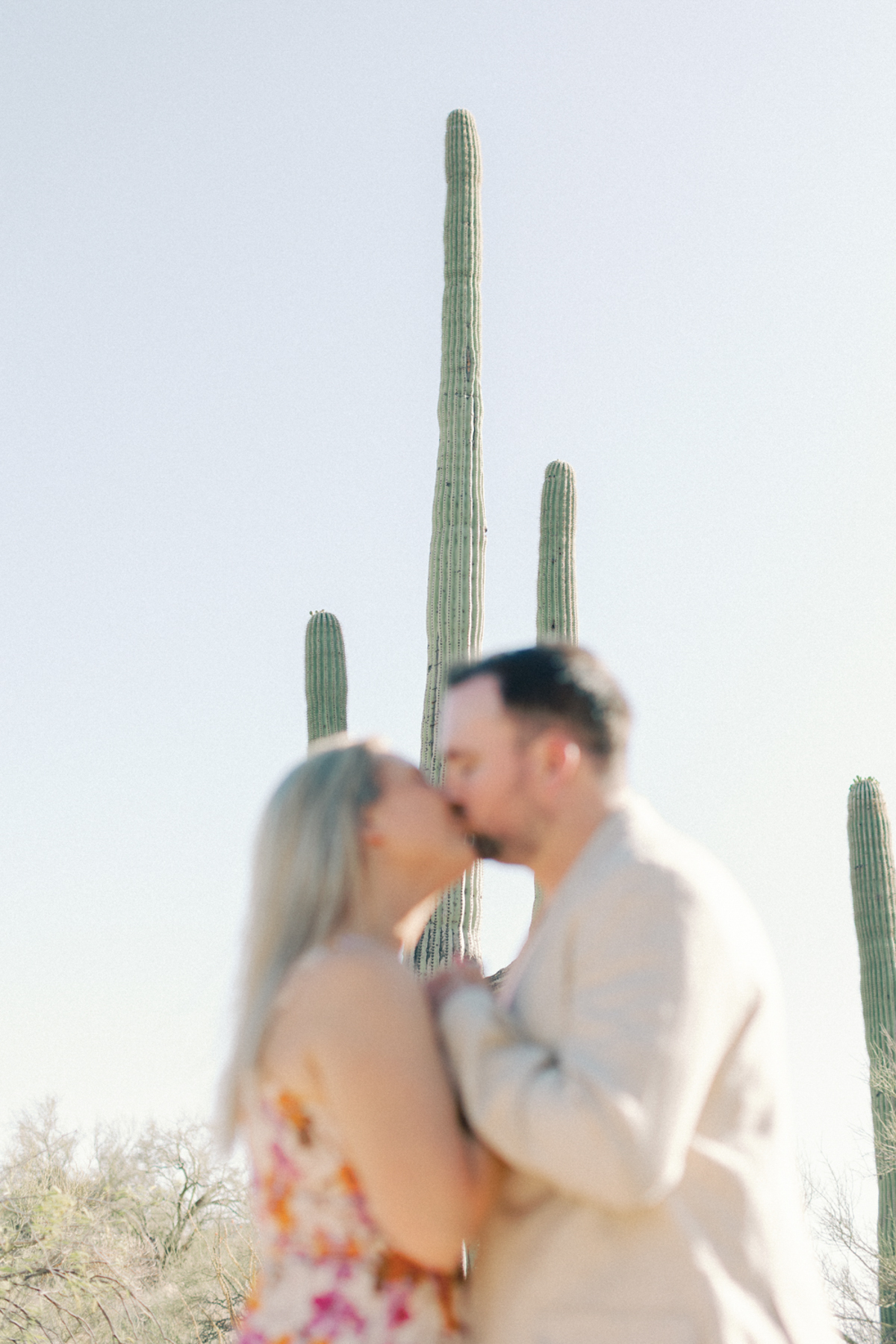 Couple out of focus with cactus behind him
