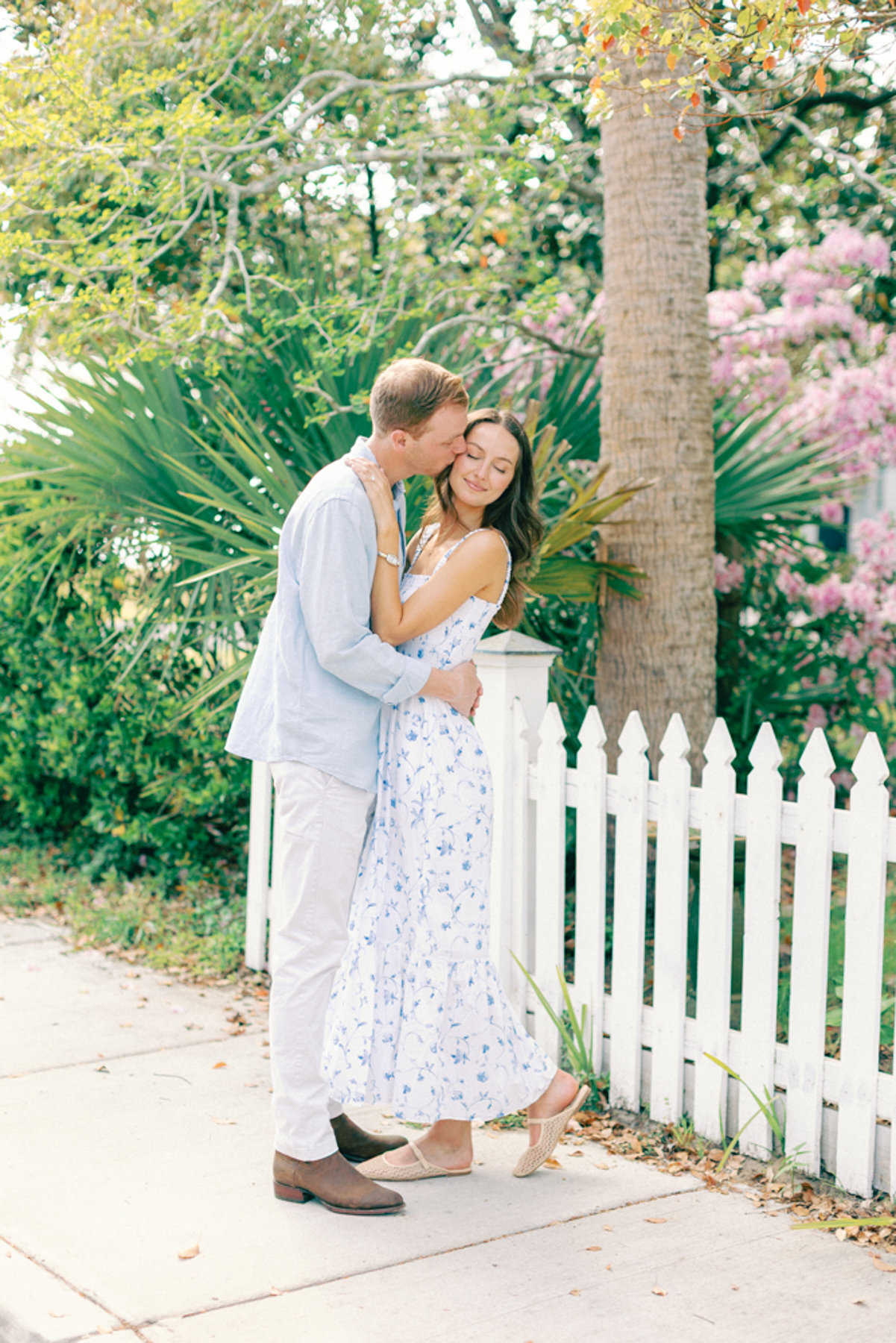 Couple snuggled up by fence