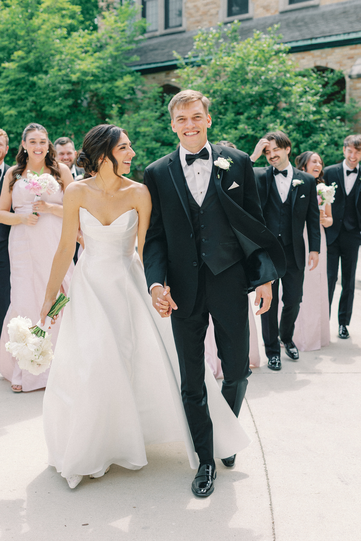Wedding party walking towards camera laughing