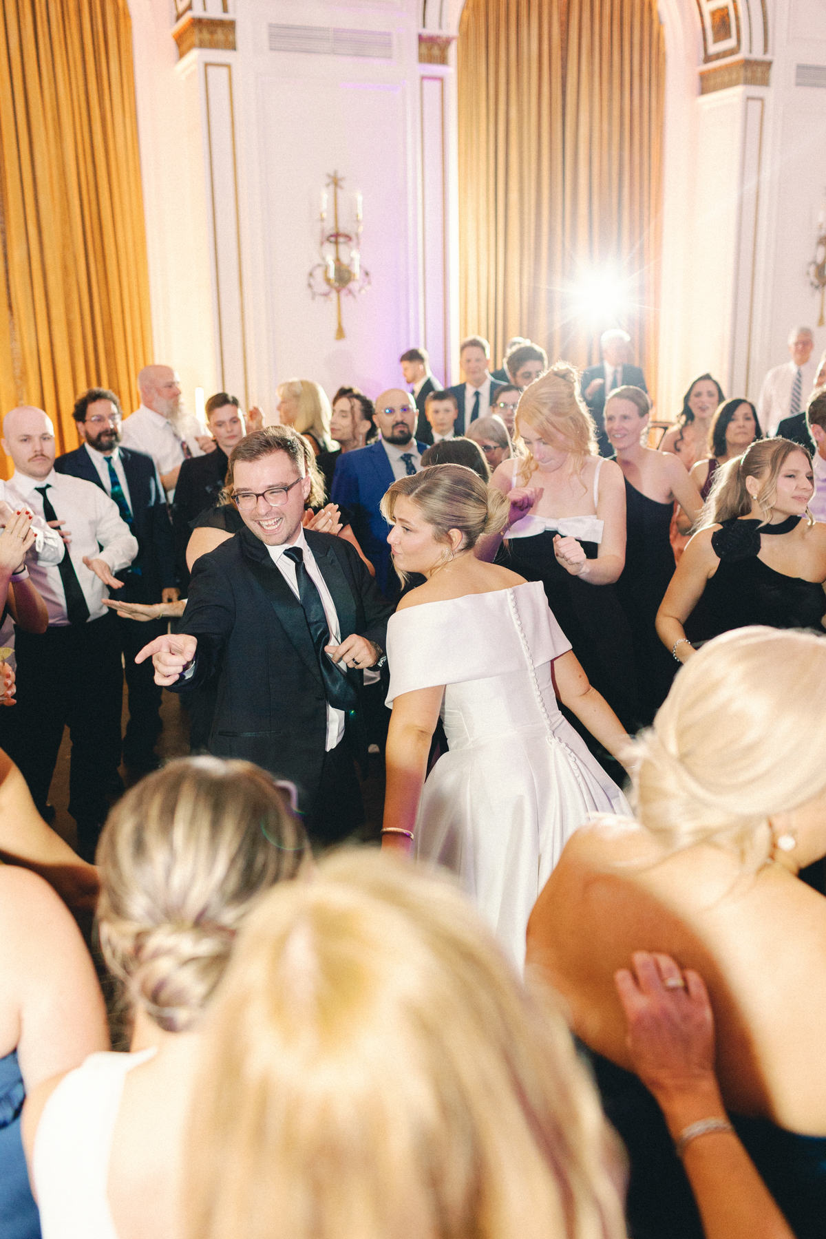 Wedding couple dancing with guests
