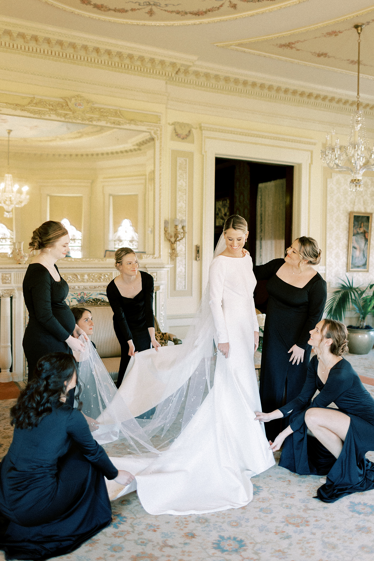 bridesmaids helping bride get into dress