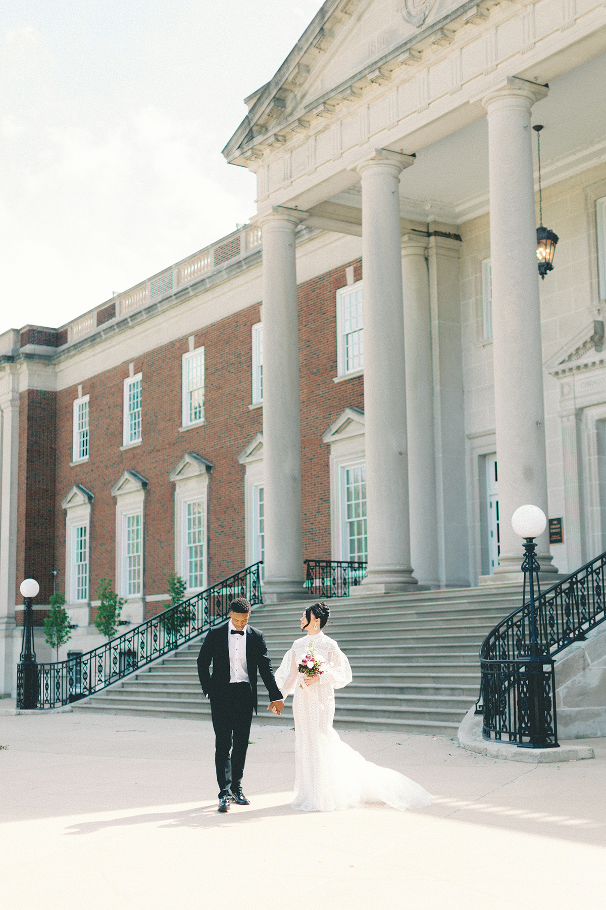 Bright and groom walking outside venue