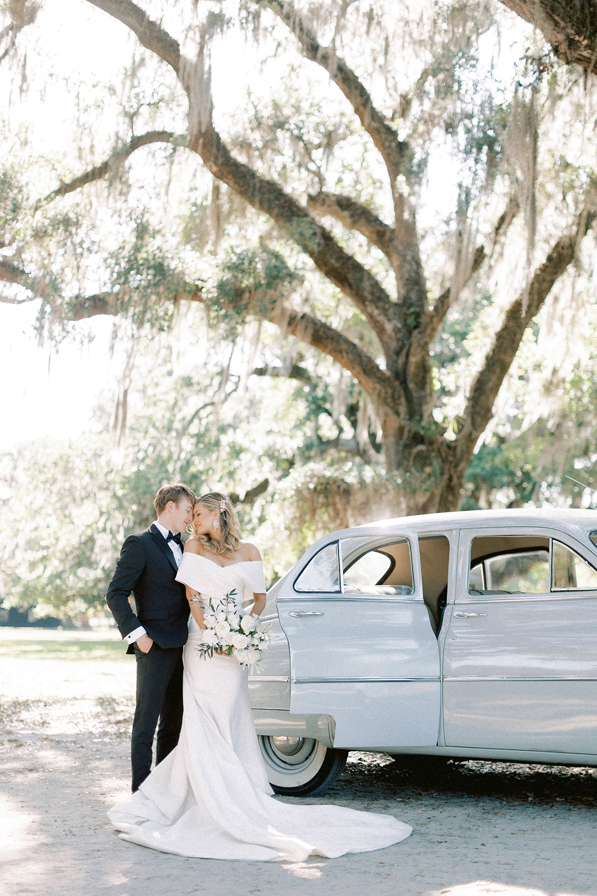 bride and groom by getaway car