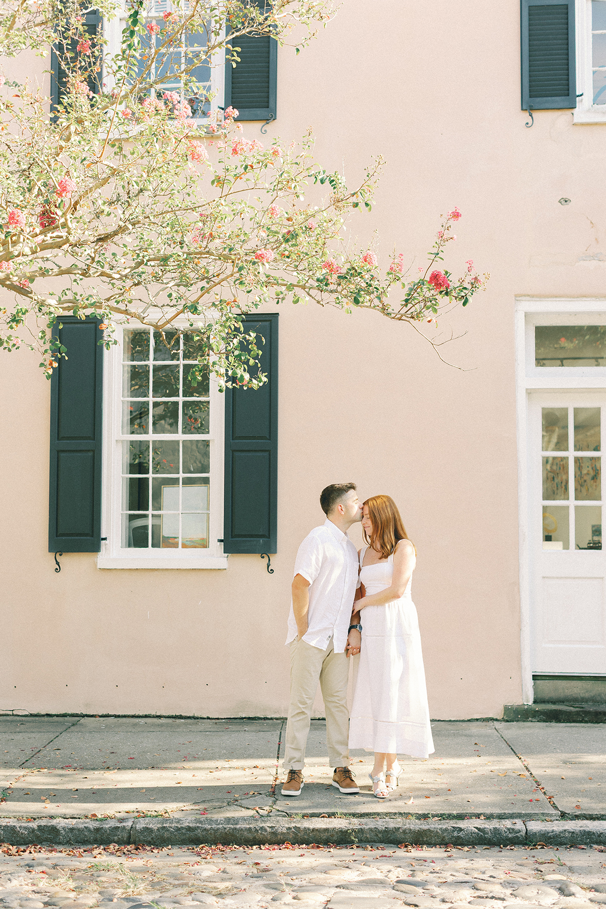 couple kissing at charleston cobblestone street