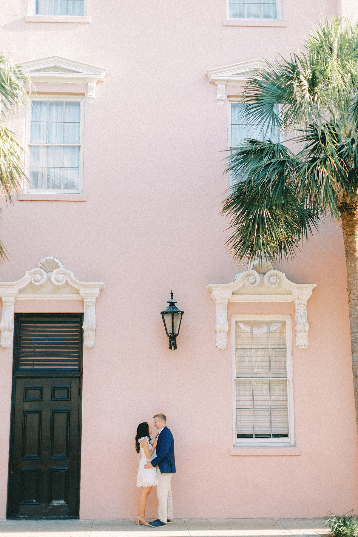 couple in front of pink building