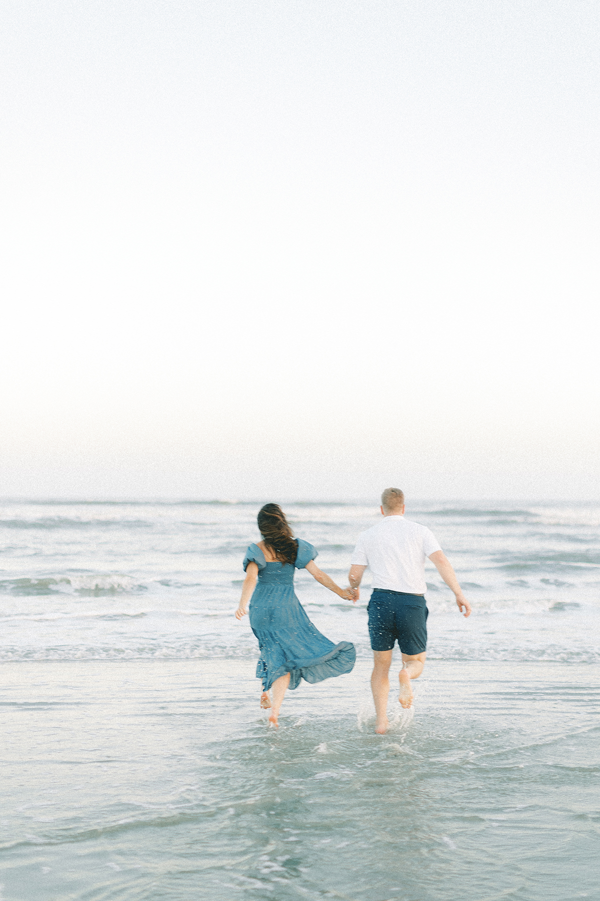couple running into water