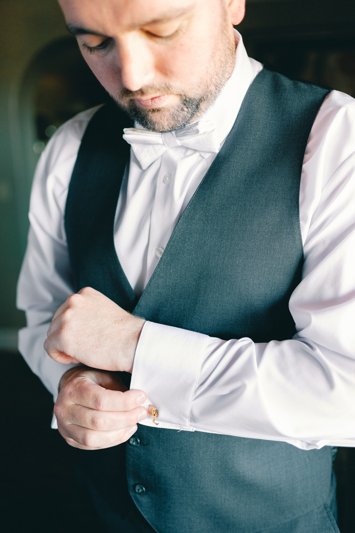 (groom) putting on cufflinks link