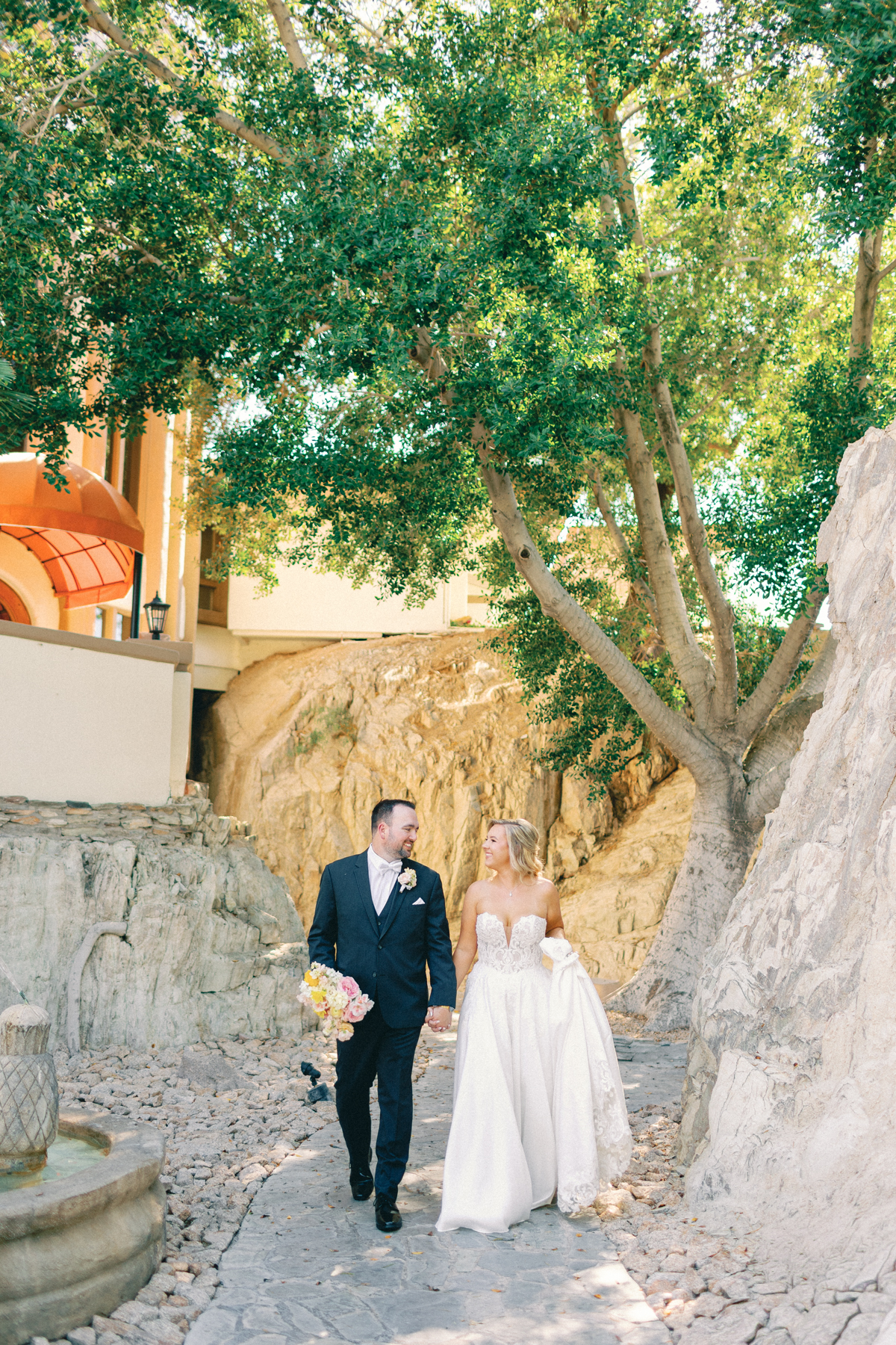 Bride and groom walking through path