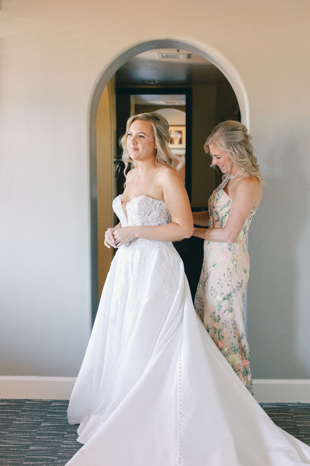 Mom putting on bride dress