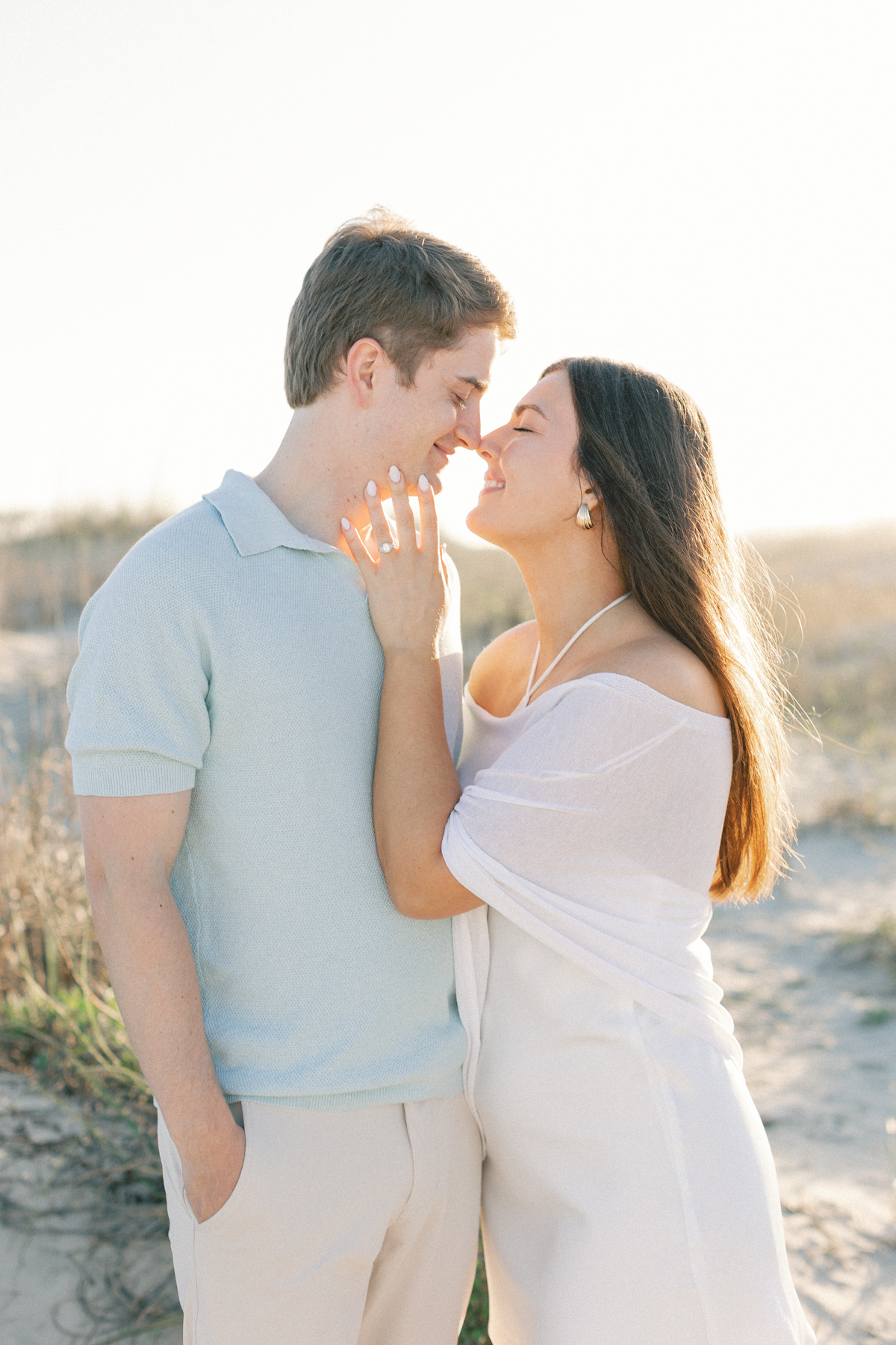 Couple snuggled up by dunes