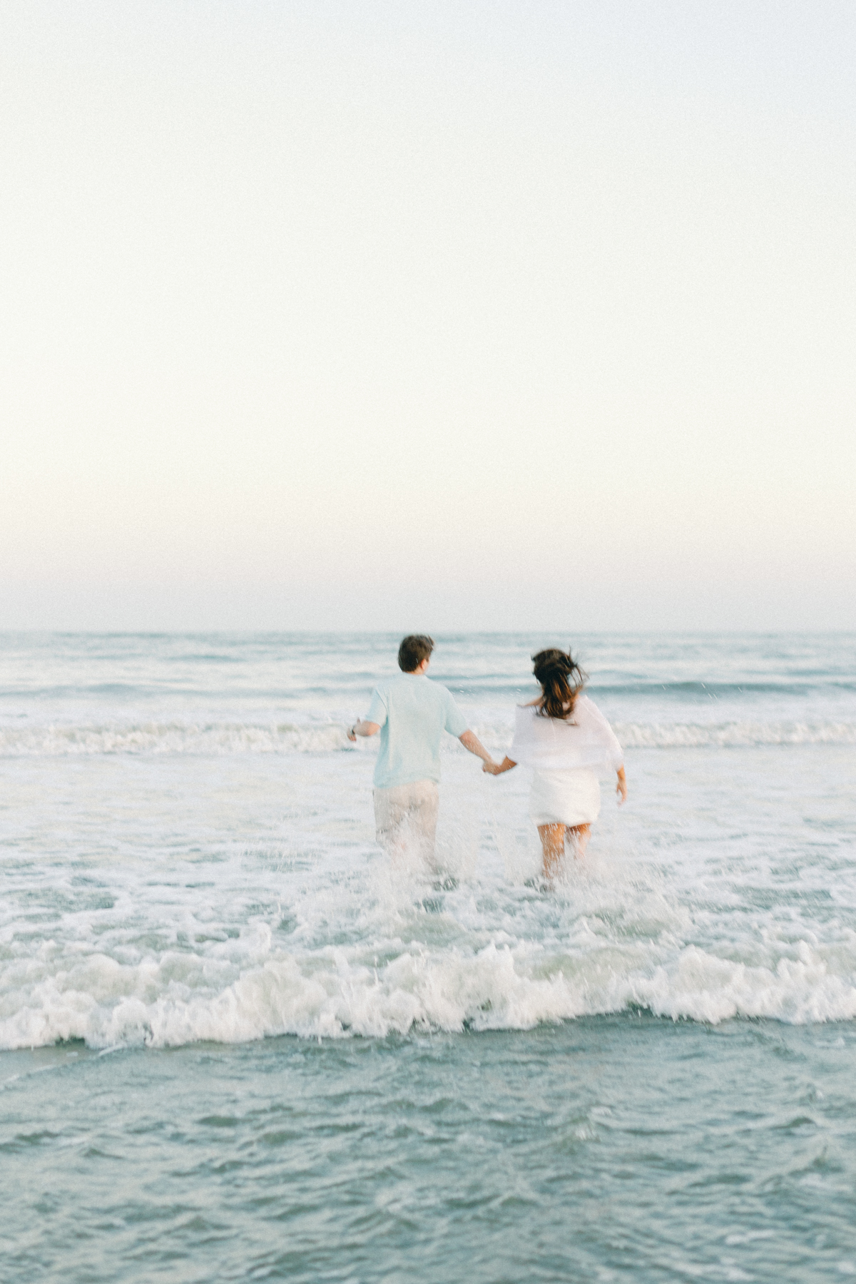 Couple running into water