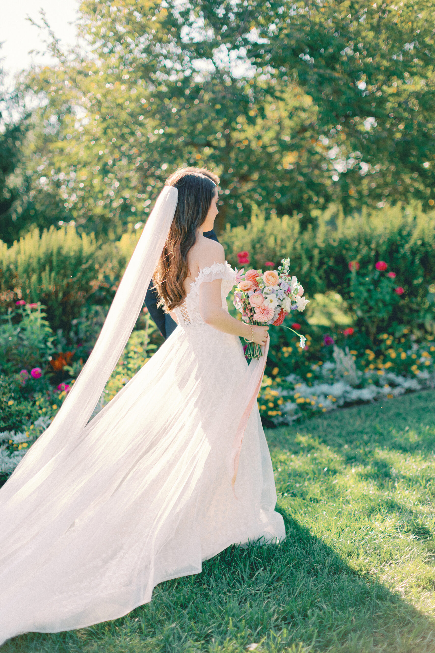 Bride with a colorful bouquet walking through a Michigan wedding garden