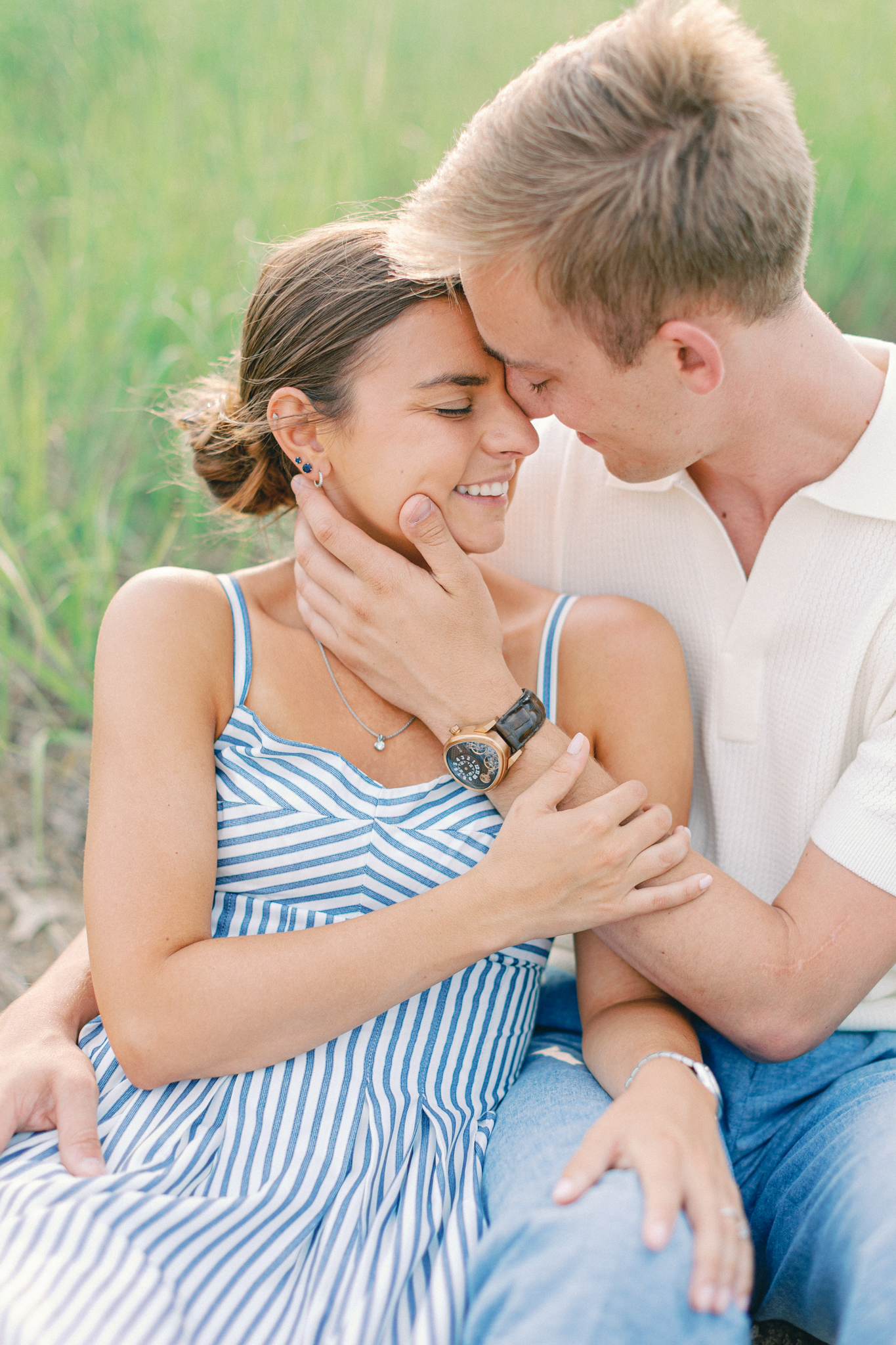 Emma and Caleb embrace forehead to forehead, laughing together during their Port Huron, Michigan engagement session.