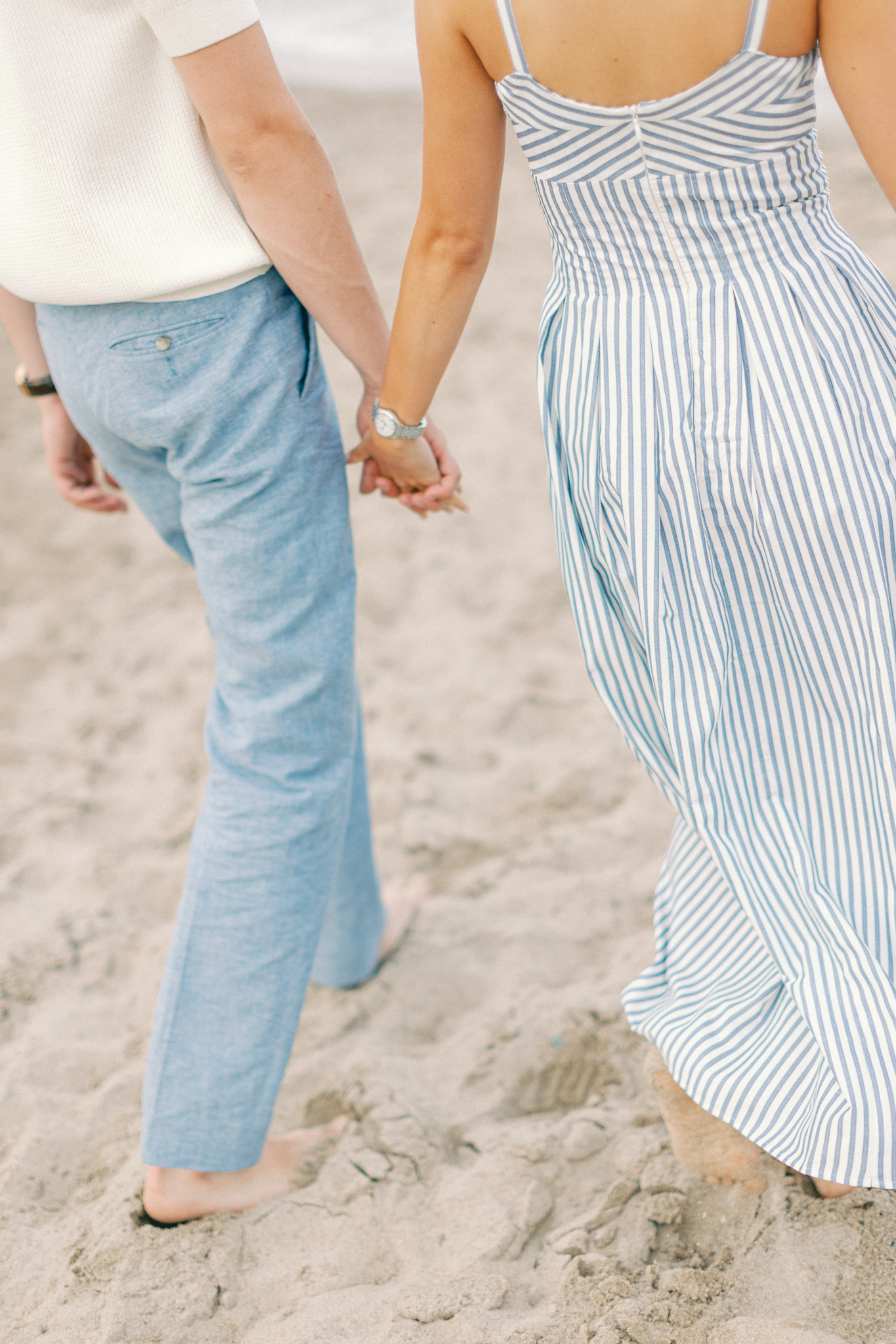Close-up of Emma and Caleb holding hands while walking on the beach in Port Huron, Michigan.