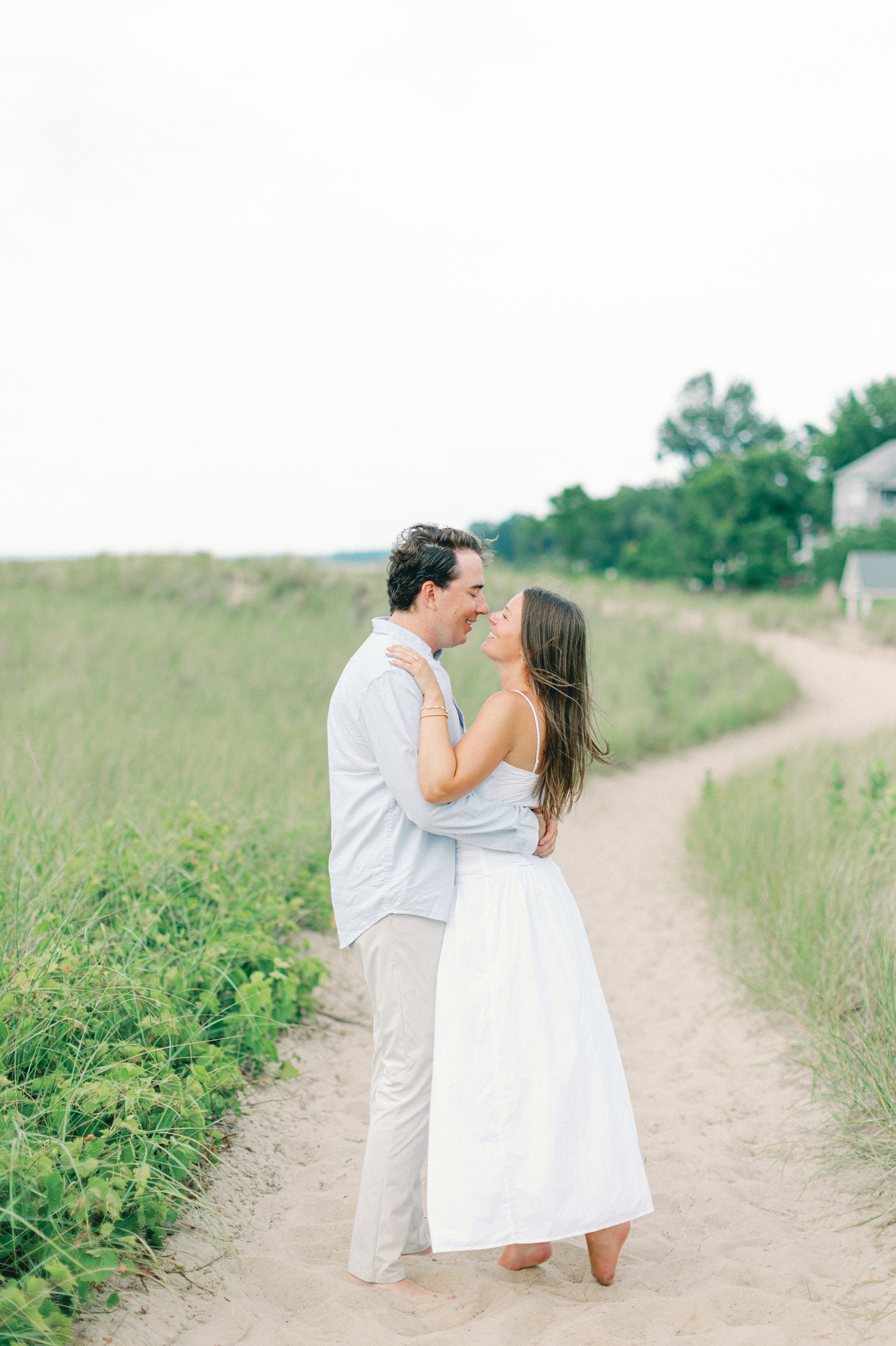 Lauren and Jason kissing on a sandy dune trail