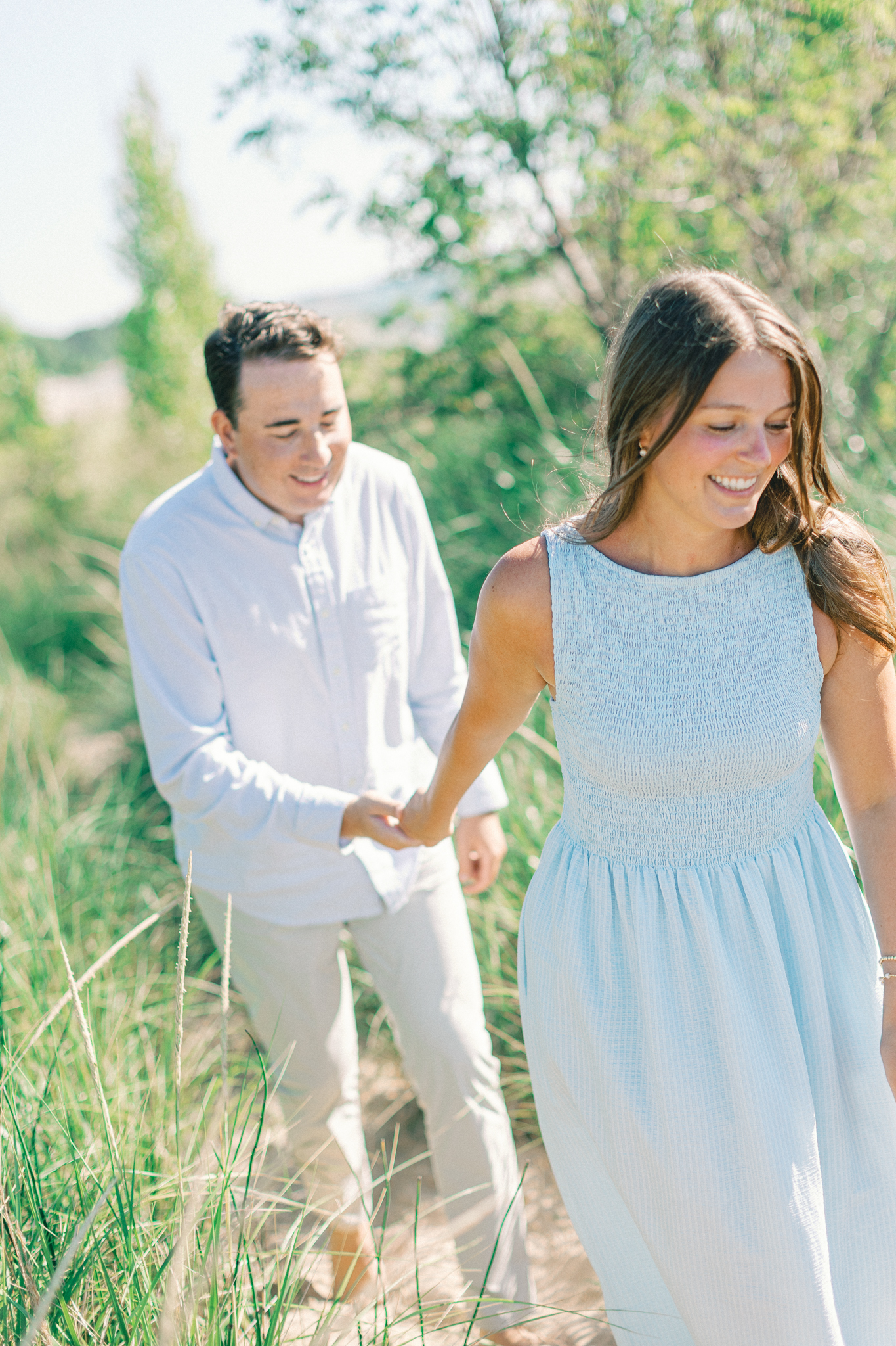 Lauren and Jason walking away from the camera up a grassy dune path