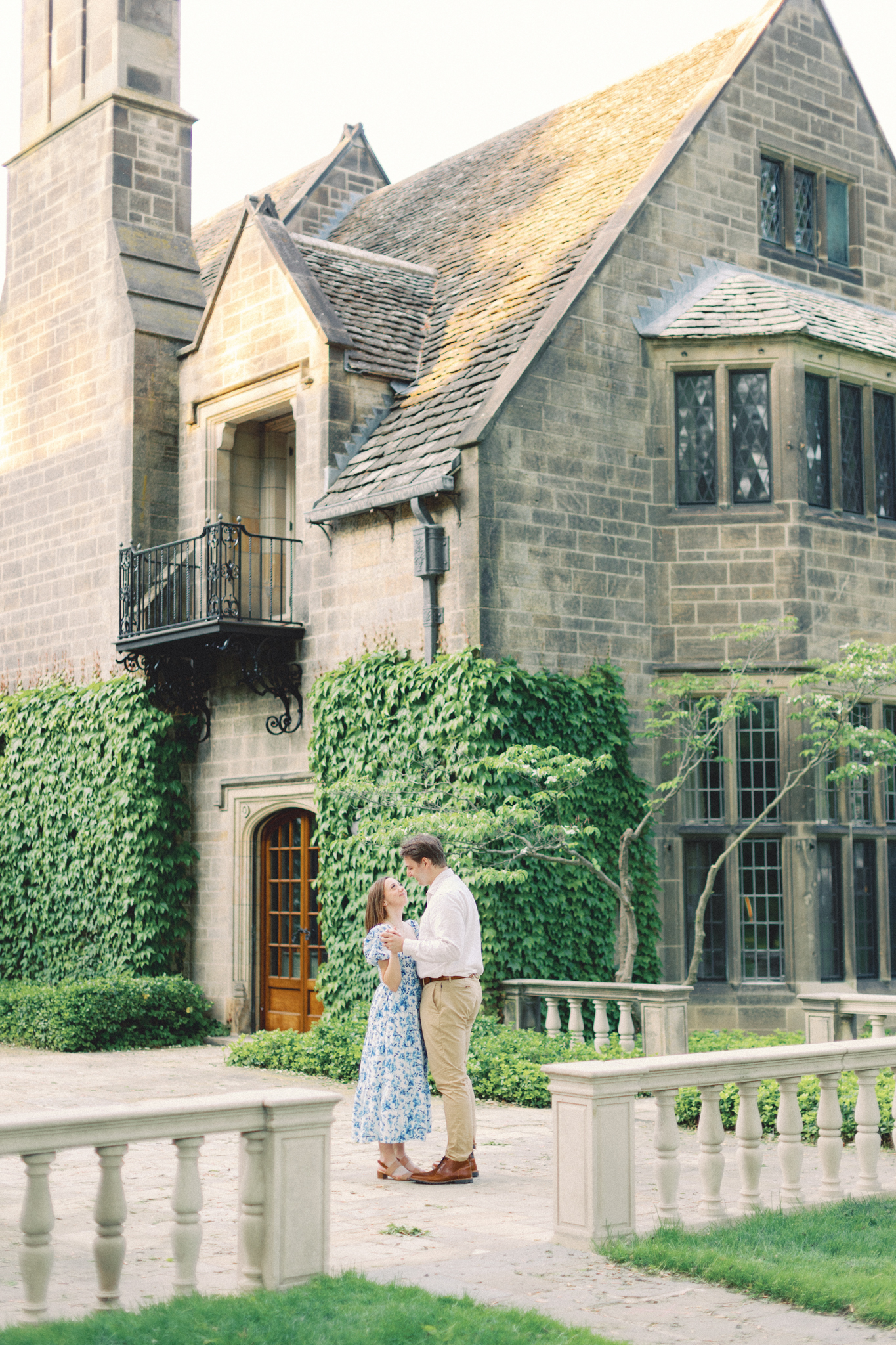 Cameron and Justin dance on the stone terrace of the Edsel and Eleanor Ford House during their Michigan engagement photography session