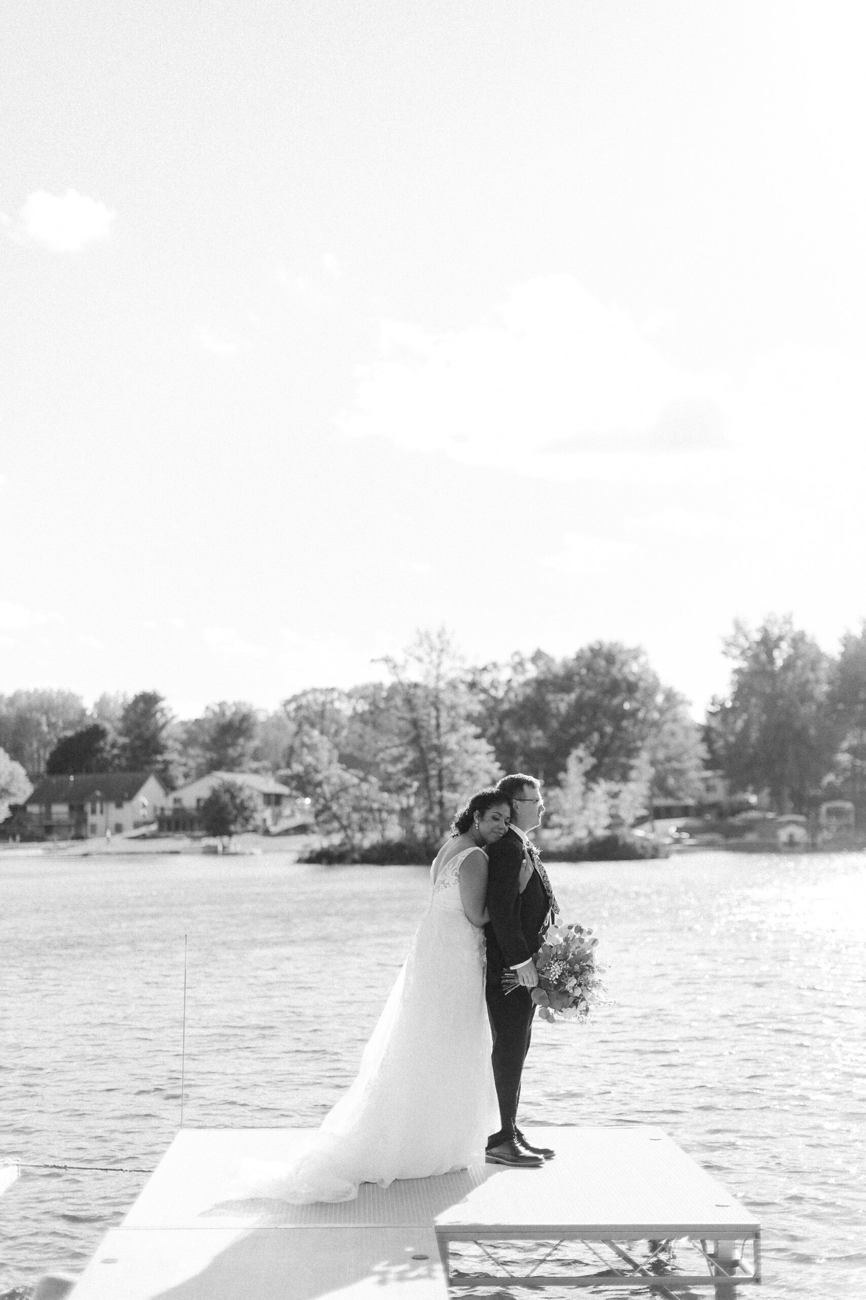 Black and white portrait of a bride and groom on a lake dock — northern Michigan wedding photographer